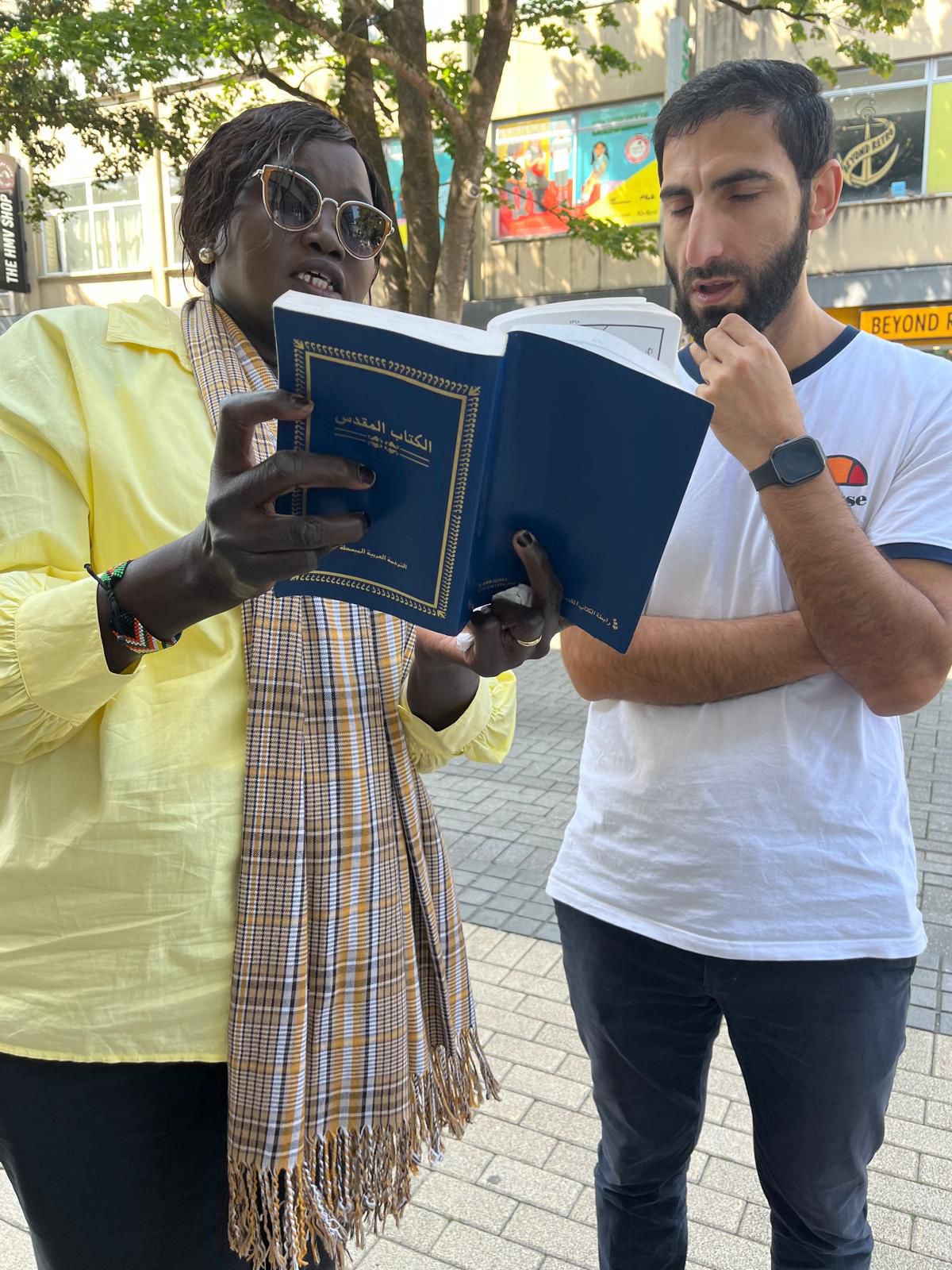A woman reading from a book to a man