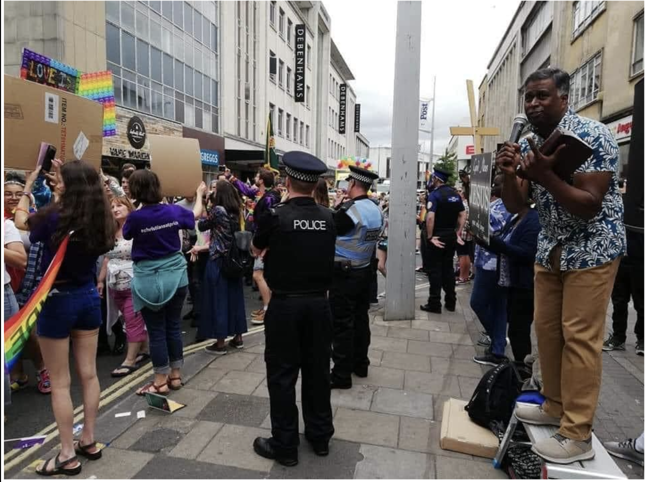 A street preacher speaking to a crowd in the street