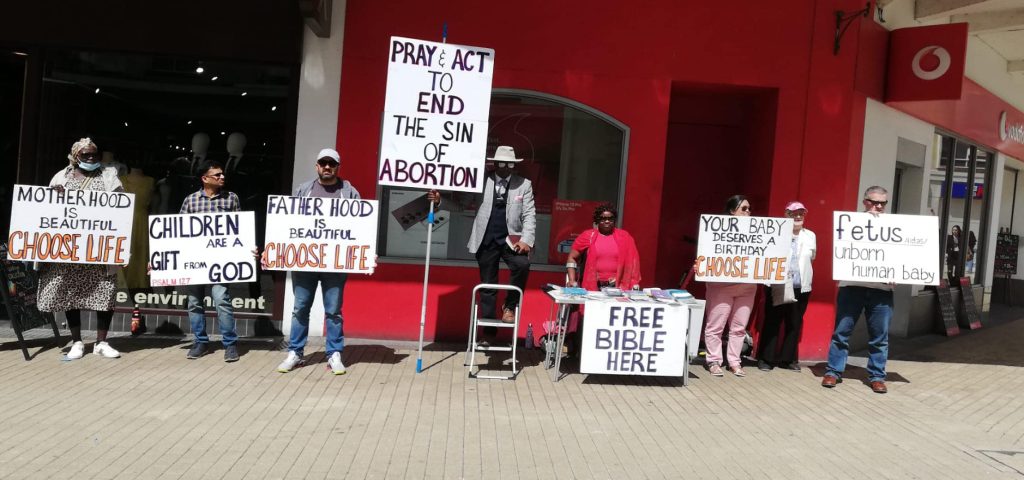 A group of people holding signs with Christian messages